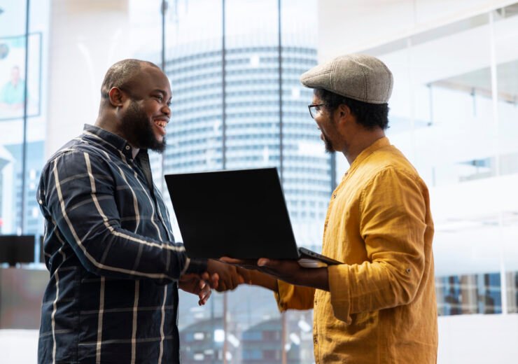 Business owner planning a property investment during office tour with broker, examining the building layout on architectural blueprints and sharing his vision. Office relocation strategy.