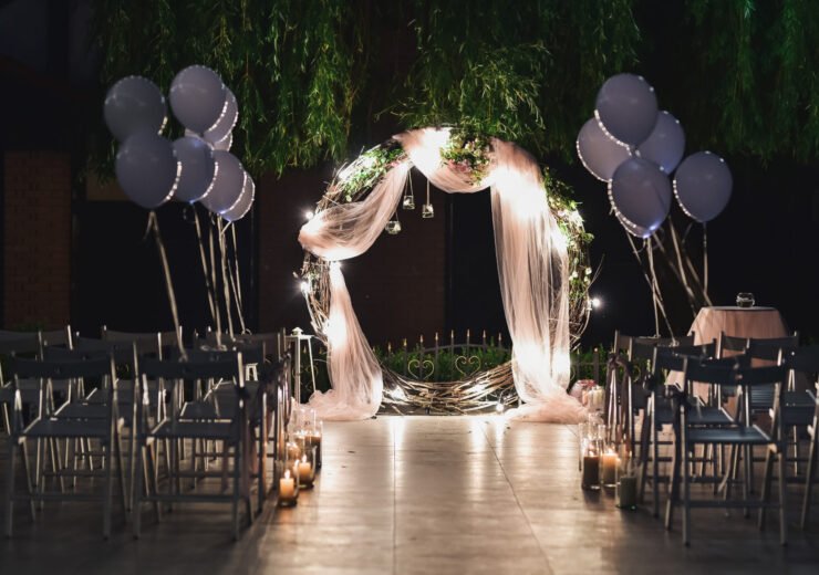 Shine wedding altar for newlyweds stands on the backyard decorated with balloons and greenery